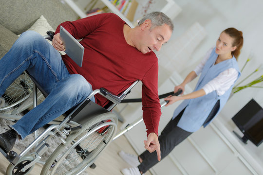 man wheelchair giving orders to carer