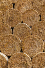 Round bales of hay stacked in a pyramid shape. Close up.