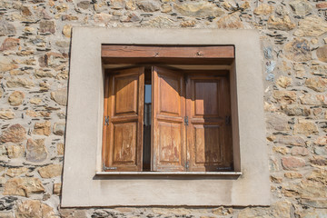 Closed wooden windows with a stone facade