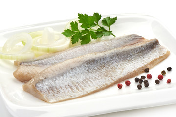 Fillet of salted marinated Atlantic herring with onion, peppercorns and parsley, isolated on white background