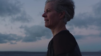 senior woman running exercising jogging on beautiful ocean seaside at sunrise enjoying active fitness lifestyle slow motion close up