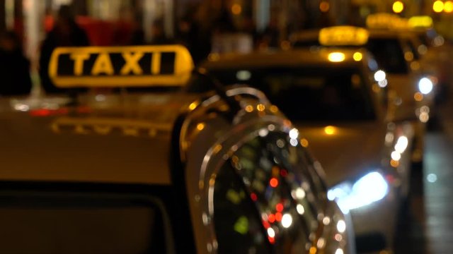 Hand held soft focus night time video of taxis and people in Berlin, Germany