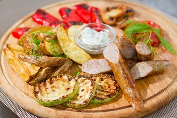 smoked sausages with grilled tomatoes, paprika, mushrooms, zucchini, fried potatoes, dill, white sour sauce, macro shallow dof food photo