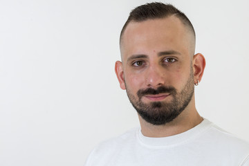 young businessman with tattoo, black t-shirt, beard and black hair, and with a white background