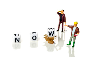 Adding white cube with letter w to the word no creating new word now on white background  background with miniature figurines