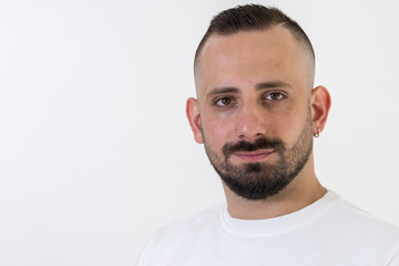 young businessman with tattoo, black t-shirt, beard and black hair, and with a white background