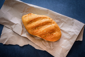 bread on the table just from the stove. Freshly baked bread on kraft paper on a dark background.