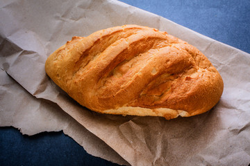 bread on the table just from the stove. Freshly baked bread on kraft paper on a dark background.
