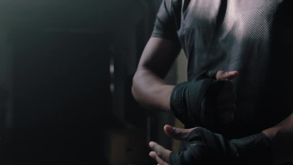 fitness man athlete preparing training workout using hand wrap attractive bodybuilder ready for intense exercise kickboxer enjoying healthy lifestyle in gym slow motion