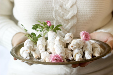 Traditional Romanian or Moldavian shortcake cookies with jam stuffing on a tray in female hands.