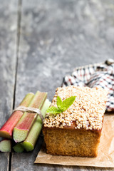 Homemade  rhubarb cake topped with sweetened oats on wooden table
