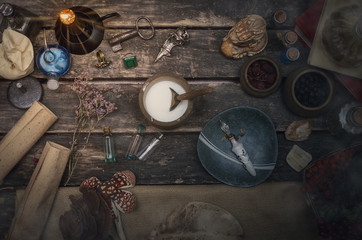 Magic potion preparation on the table of magician. Witchcraft or druidism concept background.
