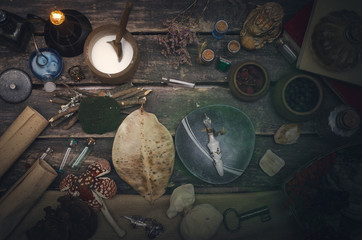 Magic potion preparation on the table of magician. Witchcraft or druidism concept background.