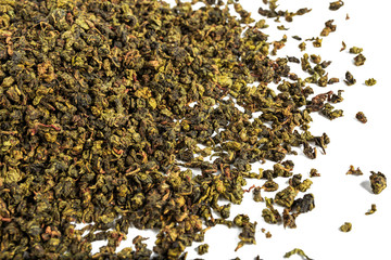 Chinese green teguanin tea, scattered on a white background, poured with a tea spatula and a tea filter.