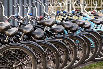 several bicycles stand in a row at the rental office or in a shop in the summer city