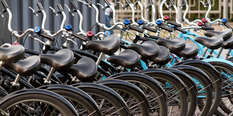 several bicycles stand in a row at the rental office or in a shop in the summer city