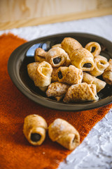 Sweet pastry with poppy seeds in a black plate.