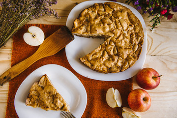 Homemade apple pie. Autumn composition with pie, apples, flowers. Flat lay food background.