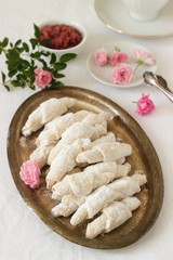 Traditional Romanian or Moldavian shortcake cookies with jam stuffing and a cup of tea on the light background.