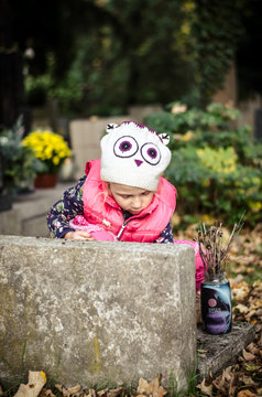 child praying in cemetery