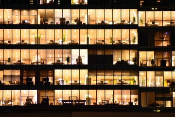 Office building at night. Late night at work. Glass curtain wall office building - Powered by Adobe