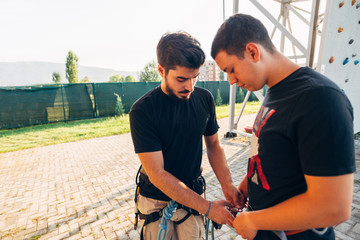 Sportive team prepare to climb on arificial wall, lead climbing, 