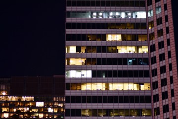 Fototapeta na wymiar Office building at night. Late night at work. Glass curtain wall office building