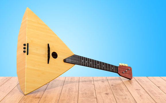 Balalaika on the wooden table. 3D rendering