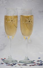 Two Glasses of Champagne and Confetti on a White Background. Close up. New Year Concept
