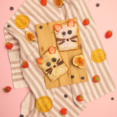 Delicious toasts with various sweet jams and fruits on pink background. Beautiful sweet sandwiches with bread, strawberry, blueberry, with chocolate. Funny animals face sandwiches for kids with bread.