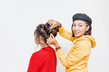 The hands of the professional female hairdresser doing Bridal or evening hairstyle with curls for her client in studio © EdNurg