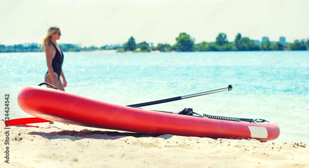 Wall mural water sports , active lifestyle. young sexy woman swimming on stand up paddle board.