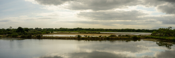 panorama d'un &eacute;tang avec un ciel nuageux, mena&ccedil;ant et son reflet
