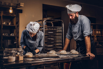 Cooking master class in bakery. Chef with his assistant showing ready samples of baking test in kitchen.
