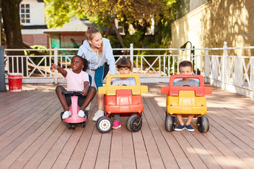 Kinder in einer Kita fahren mit Tretautos