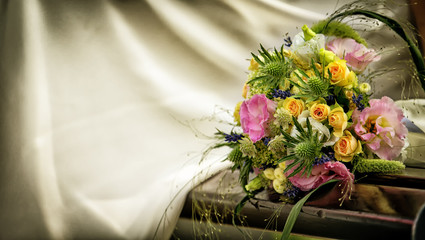 Wedding bouquet with roses on a wooden bench