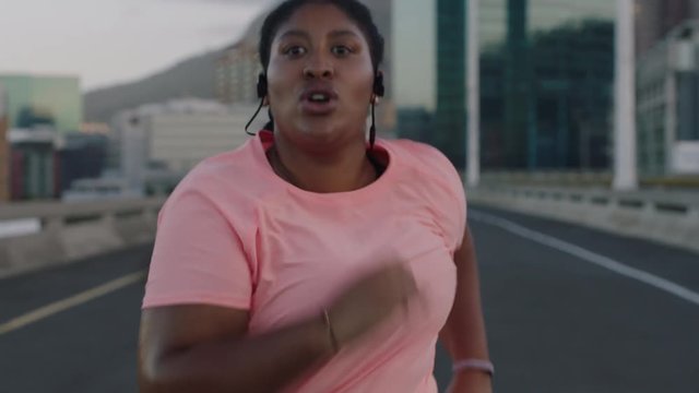 young overweight woman runner resting exhausted after difficult running cardio exercise tired black female in urban city at sunrise