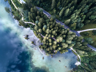 Aerial view of the road near the lake and the forest from above