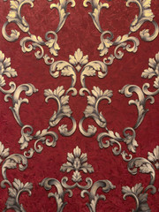Golden monograms on a dark red background. Texture, surface, background decor.Beautiful pattern, ornament