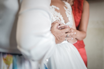 Obraz na płótnie Canvas bride putting a wedding ring on grooms finger
