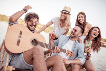 Man is play guitar for his friends