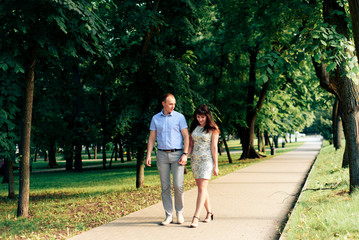 young loving couple walking in the park outdoors