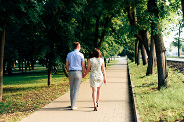 young loving couple walking in the park outdoors