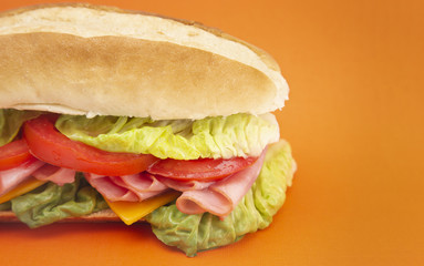 Ham Sandwich with Lettuce Cheese and Tomatoes on a White Bun