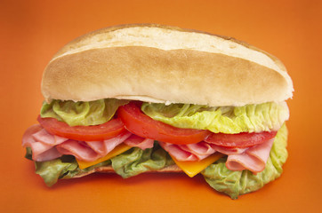 Ham Sandwich with Lettuce Cheese and Tomatoes on a White Bun