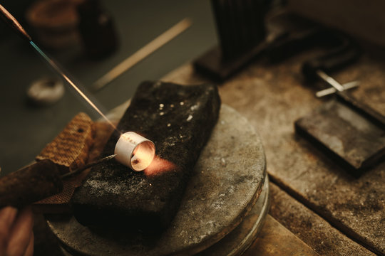 Jeweler solders a metal ring