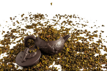 dry leaves of tea tieguanyin, scattered around a porcelain teapot, a tea blade.