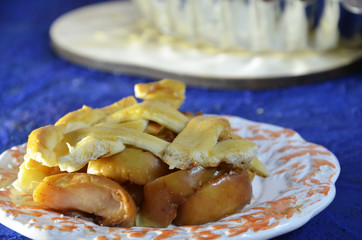 Whole apple pie, top view, a piece is taken out with a chrome cake server