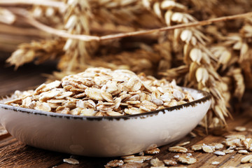 Oatmeal and oatmeal on the wooden background. Healthy eating concept