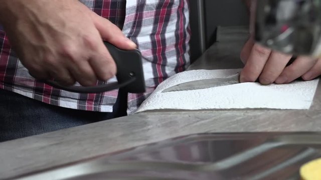 The man is sharpening a kitchen knife